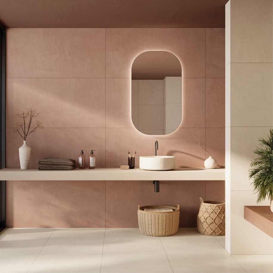 Modern bathroom with pink tiled walls, a sink, and decorative elements.