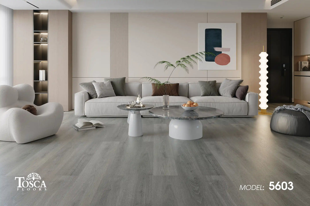 Modern living room with gray flooring, furniture, and artwork.