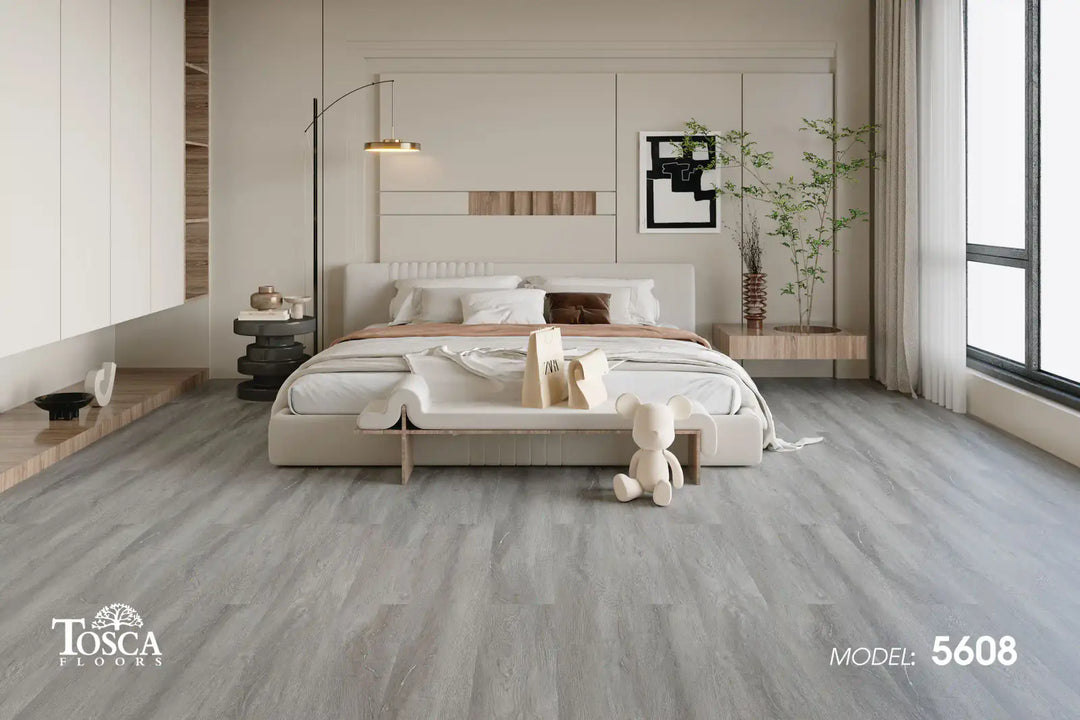 Modern bedroom with gray flooring, bed, and decor, featuring Tosca Floors branding.