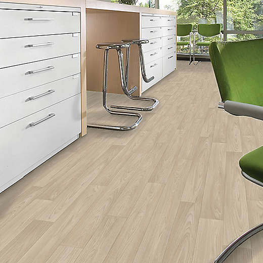 Modern office interior with light wood flooring, white cabinets, and green chairs.