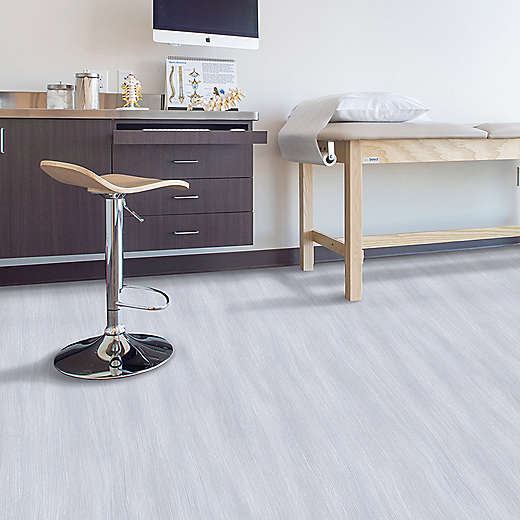 Modern office or medical room with a stool, desk, and examination table.