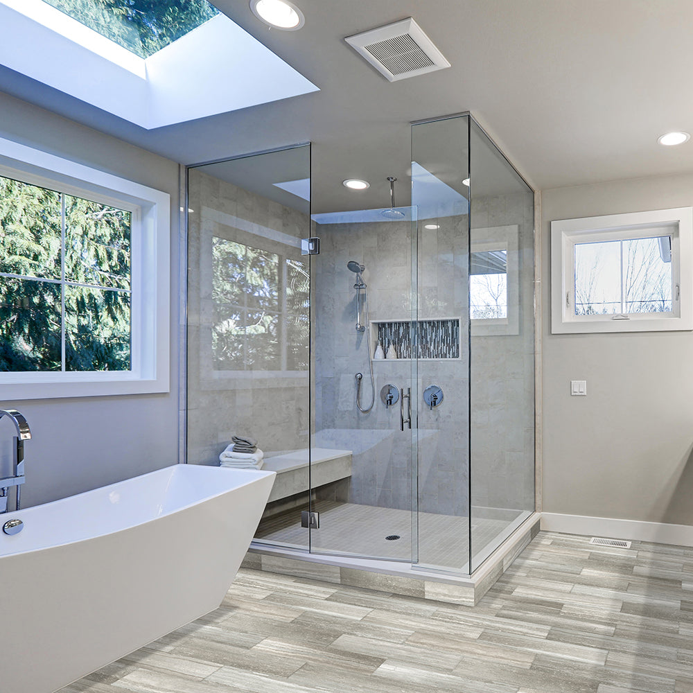 Modern bathroom with glass shower enclosure, bathtub, and skylight.