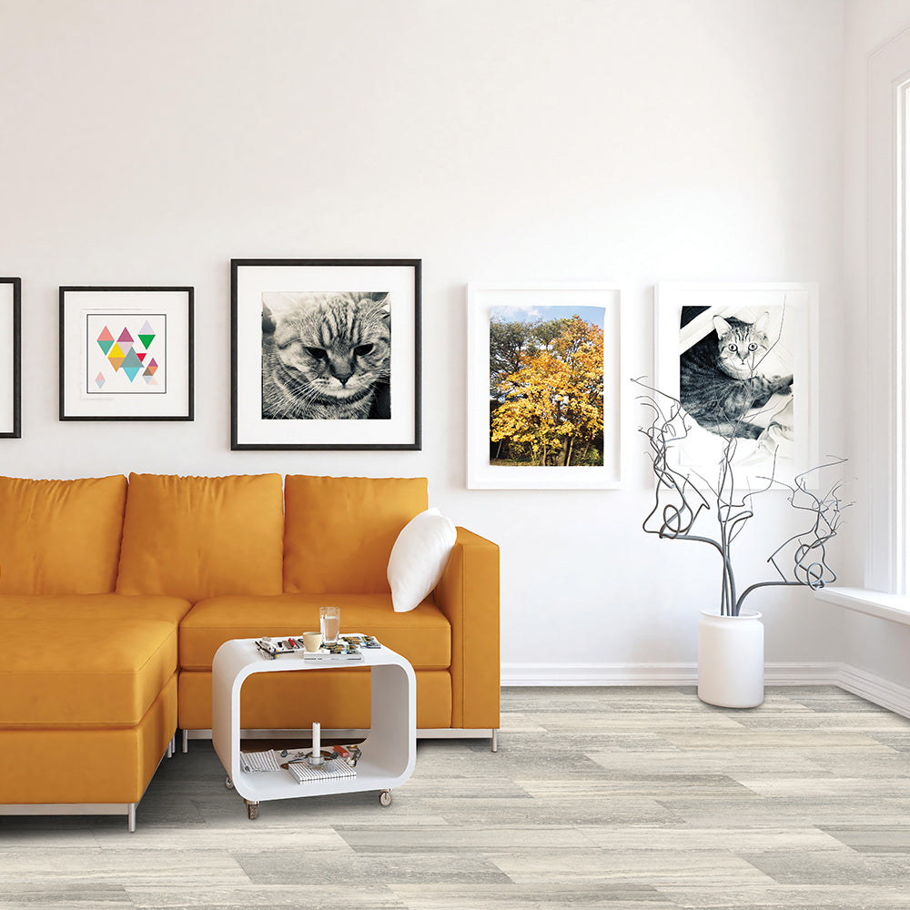 Modern living room with orange sectional sofa, white side table, and framed artwork on the wall.