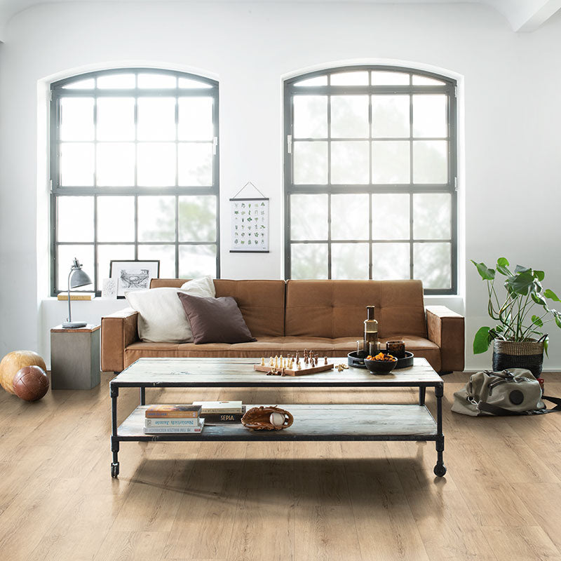 Modern living room with a brown sofa, coffee table, and decorative items.