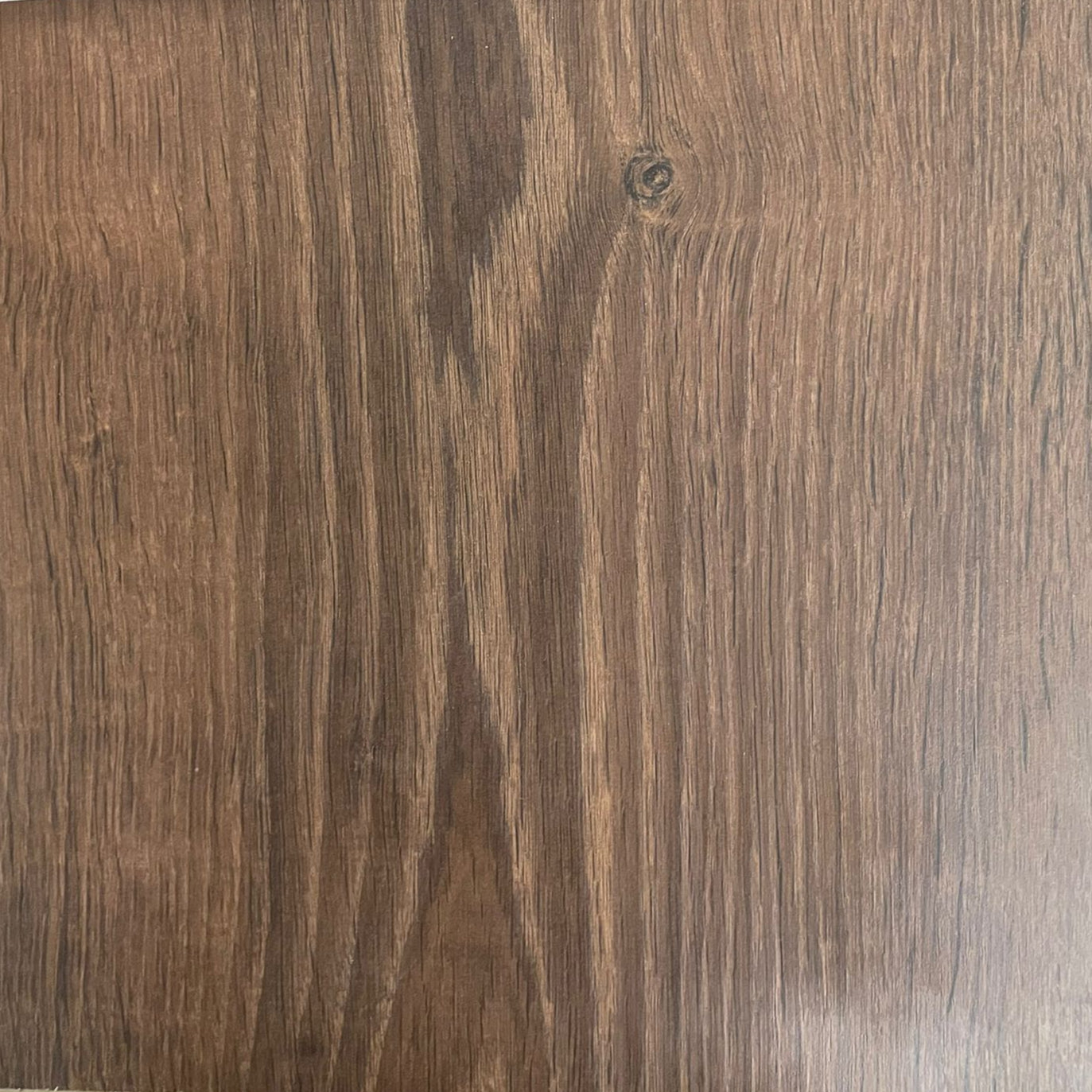 Close-up image of a wood flooring surface with a brown color and visible wood grain patterns.