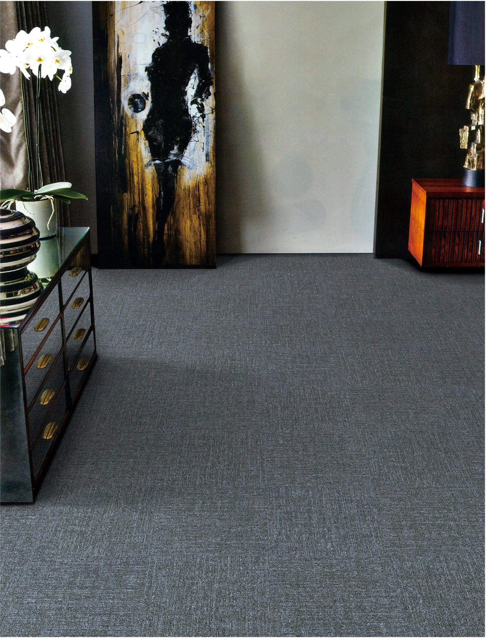 Gray carpeted room with a large abstract painting on the wall