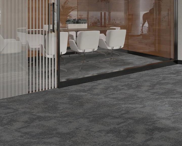 Modern office interior with gray carpeted floor and glass walls.