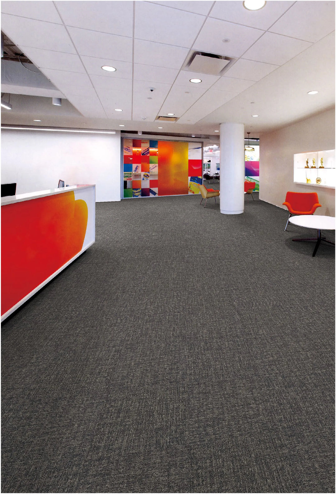 Modern office interior with gray carpet, colorful walls, and reception desk.