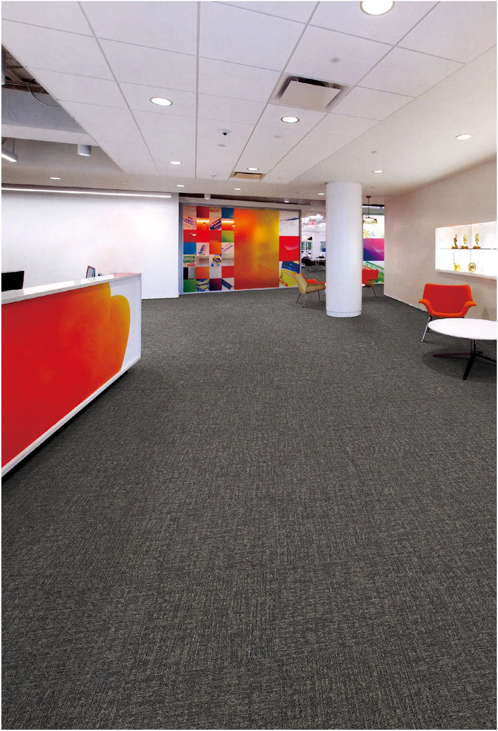 Modern office interior with gray carpet, colorful walls, and reception desk.