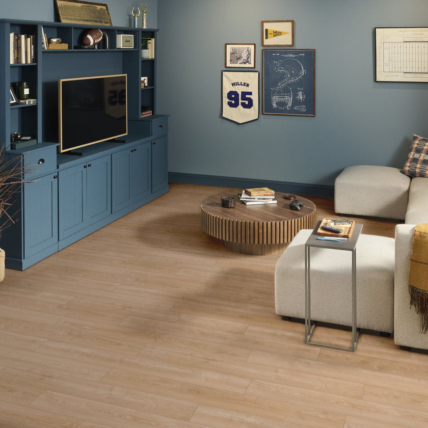 Living room with blue entertainment center, TV, and decorative items on a wooden floor.