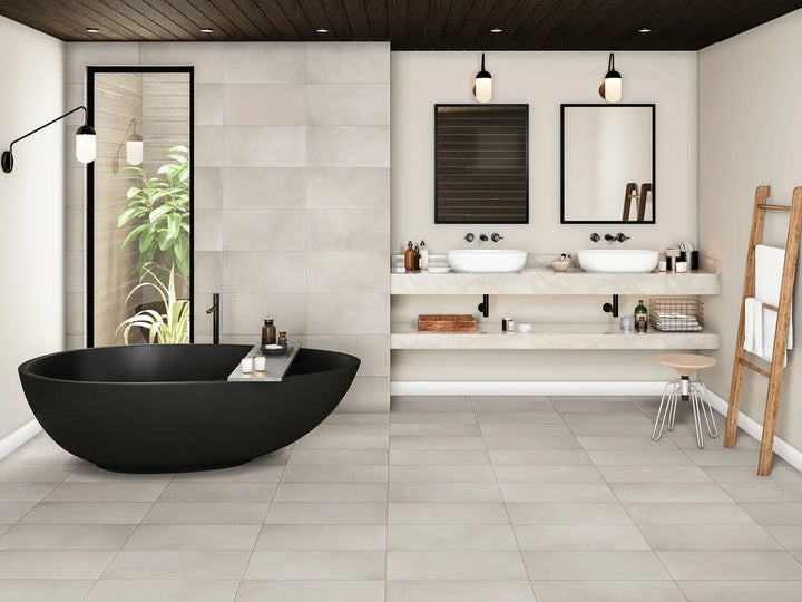 Modern bathroom with black freestanding bathtub, white vanity, and tiled walls.
