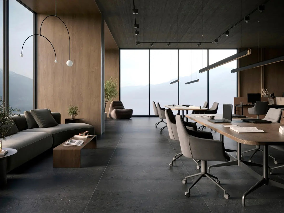 Modern office interior with a large window view, gray sofa, and wooden desk.