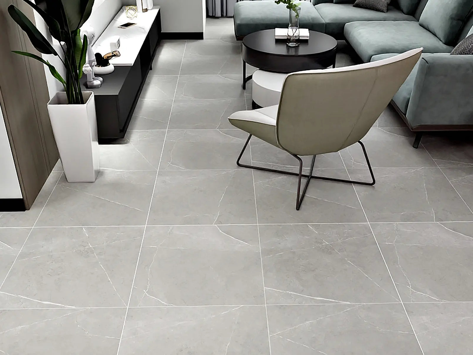 Modern living room with gray tiles, a chair, and a couch.