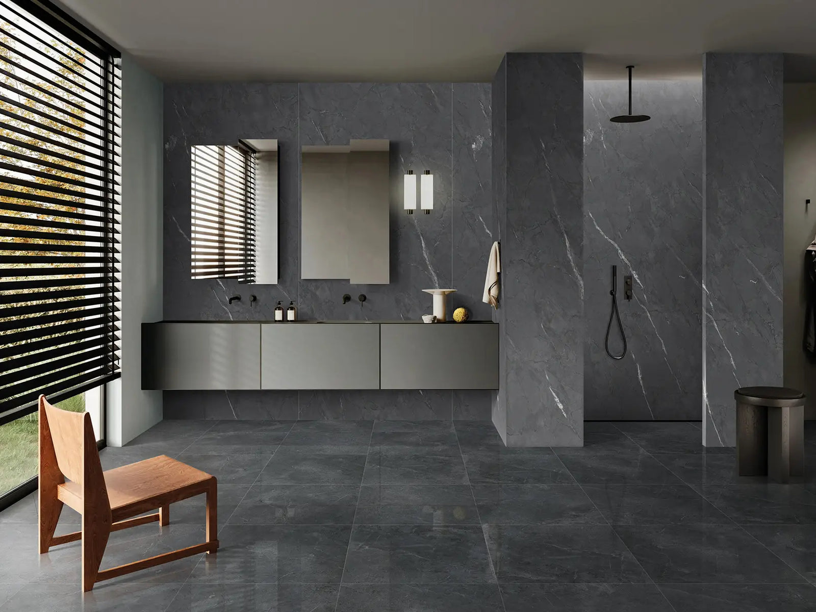 Modern bathroom with gray tiles, a wooden chair, and a shower area.