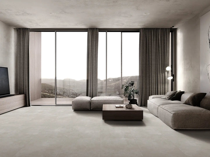 Modern living room with large windows, gray sofa, and coffee table.