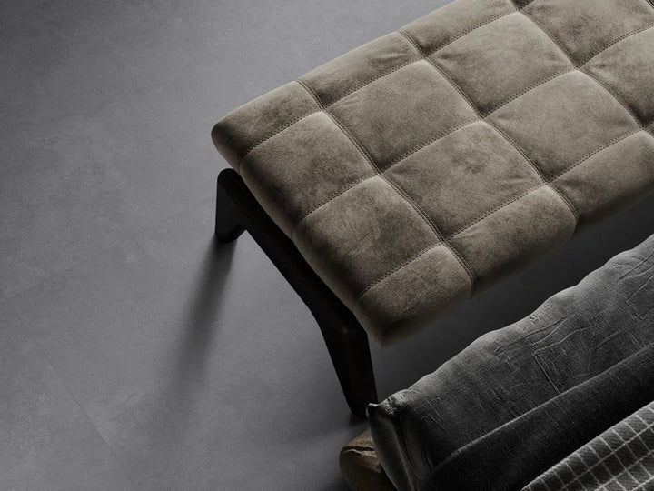 Brown upholstered bench on a gray floor