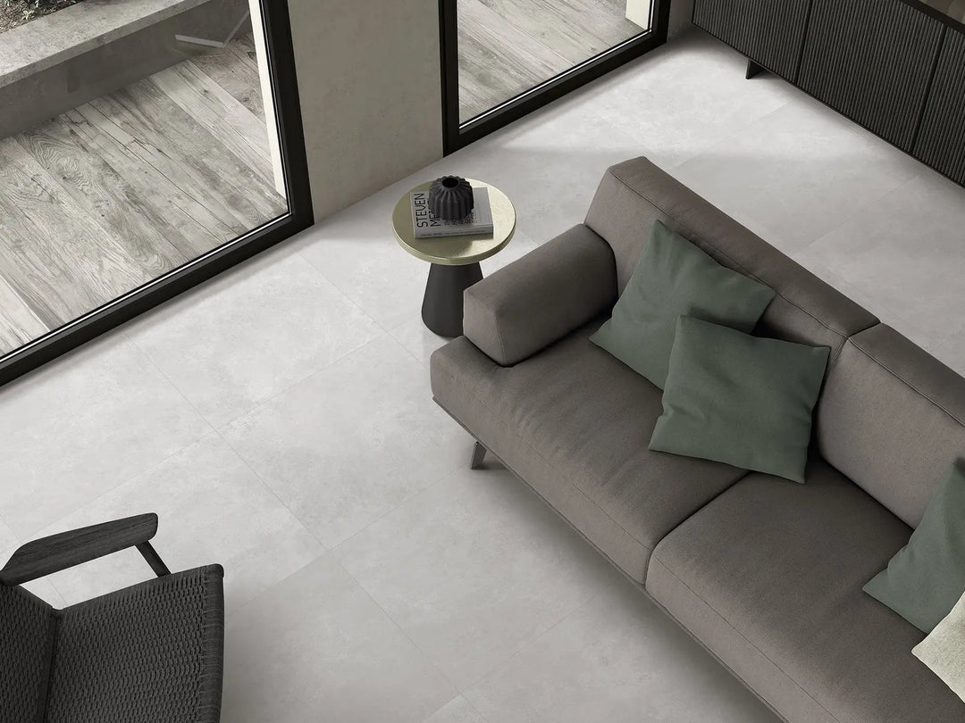 Modern living room with a gray sofa, green cushions, and a small round table.