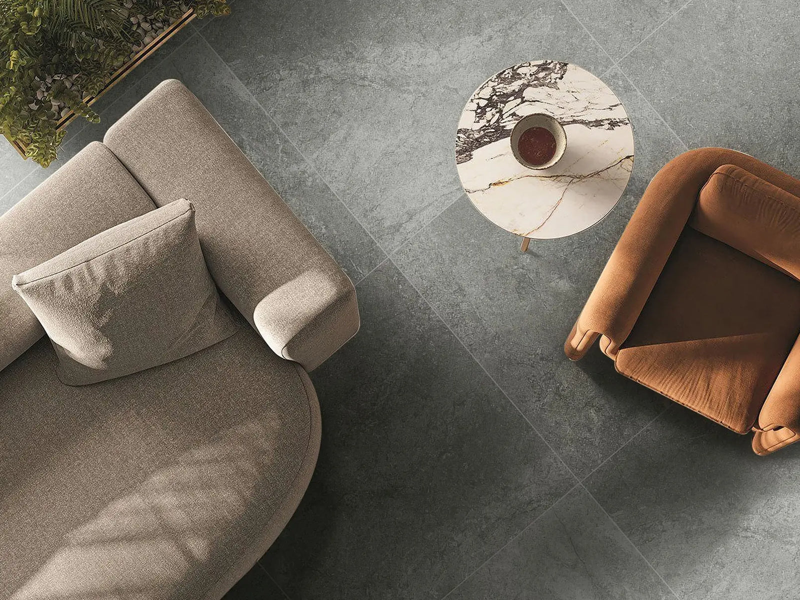 Modern living room with a gray sofa, brown armchair, and round marble coffee table.