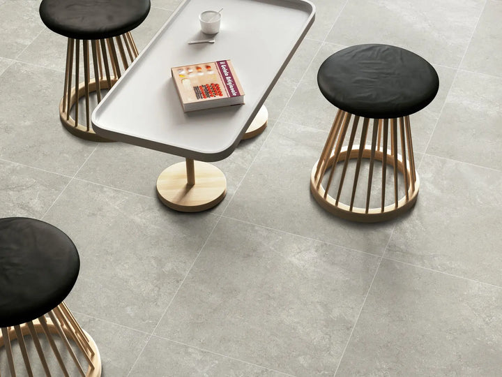 Modern coffee table with stools on a gray tiled floor