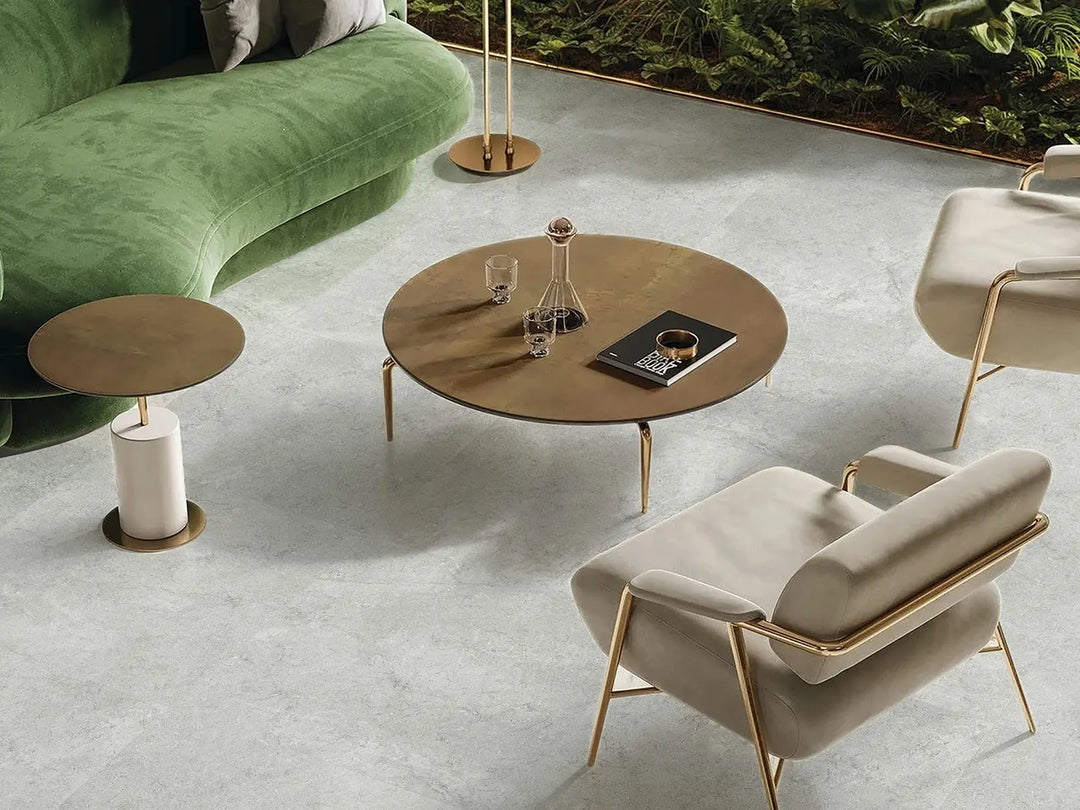 Modern living room with a green sofa, round wooden coffee table, and beige armchair.