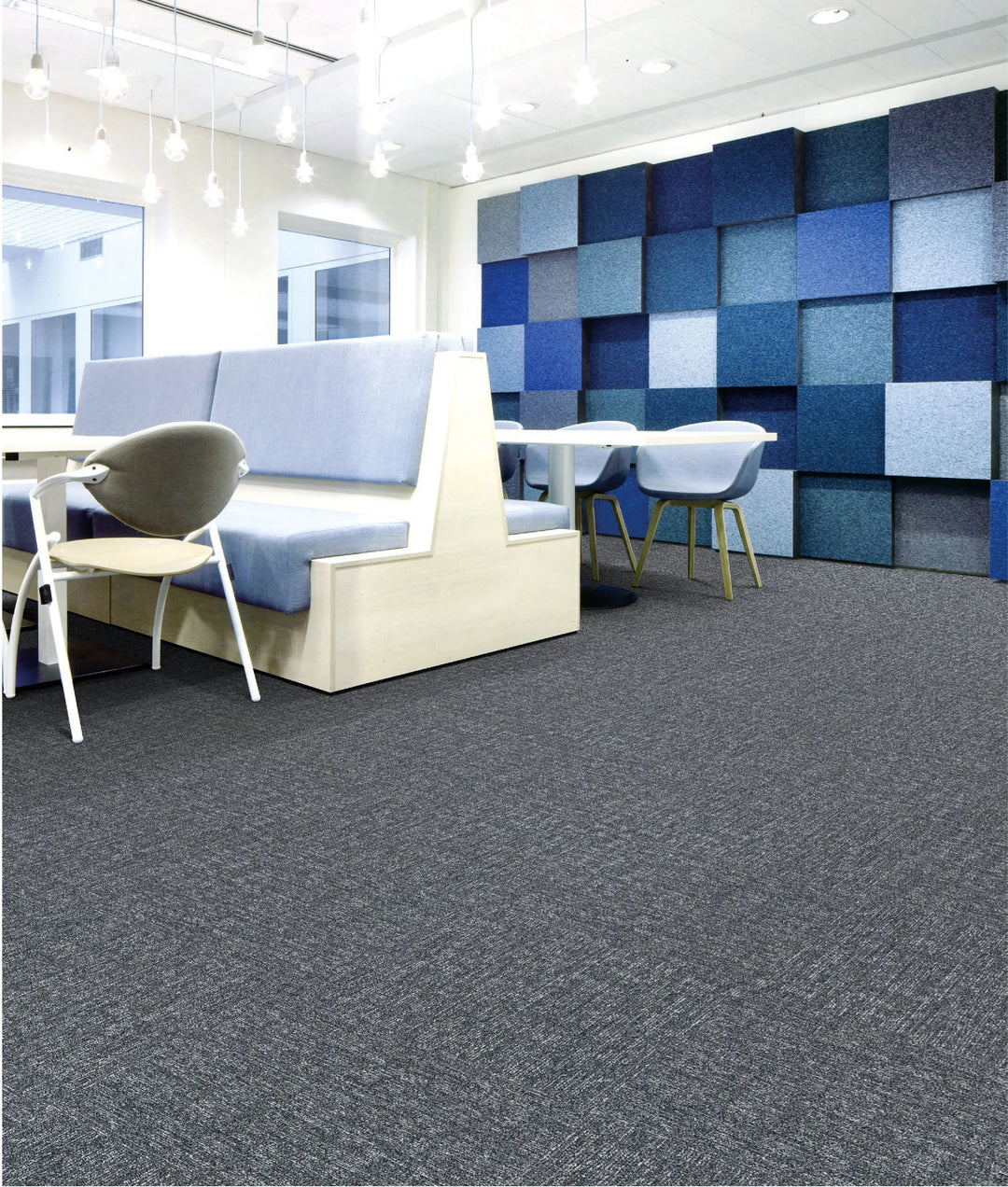 Modern office interior with blue acoustic wall panels and gray carpet.