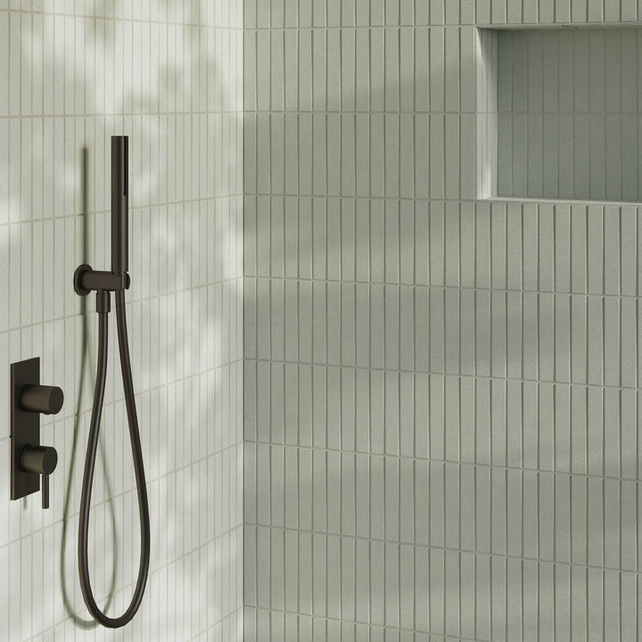 Shower setup with black fixtures on a tiled shower wall