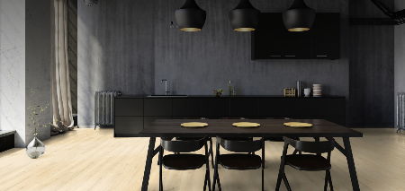 Modern kitchen with black dining table and chairs against a gray wall.