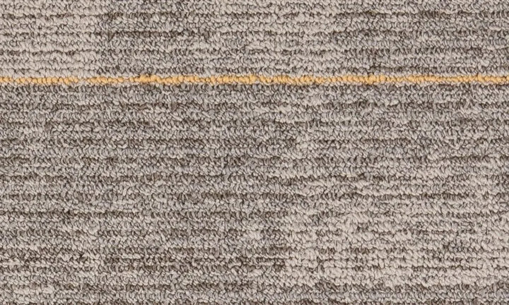 Close-up of a textured brown carpet with a gold line