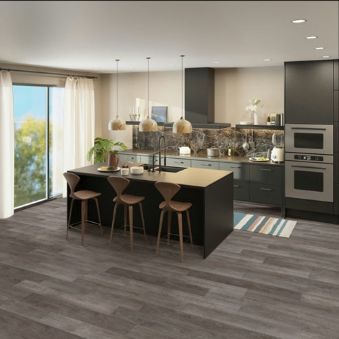 Modern kitchen with island, chairs on grey vinyl flooring 