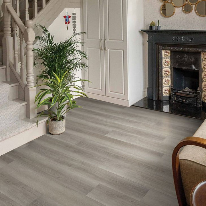 Living room with wooden flooring, staircase, and fireplace.