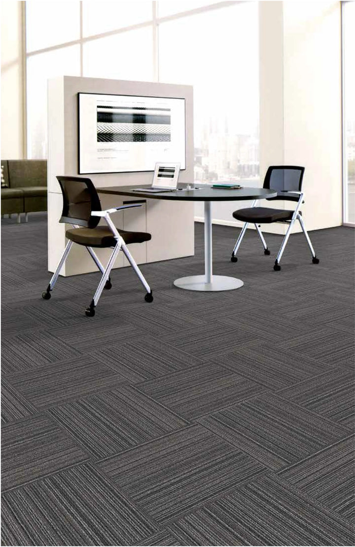 Modern office interior with gray carpet tiles and a round table.