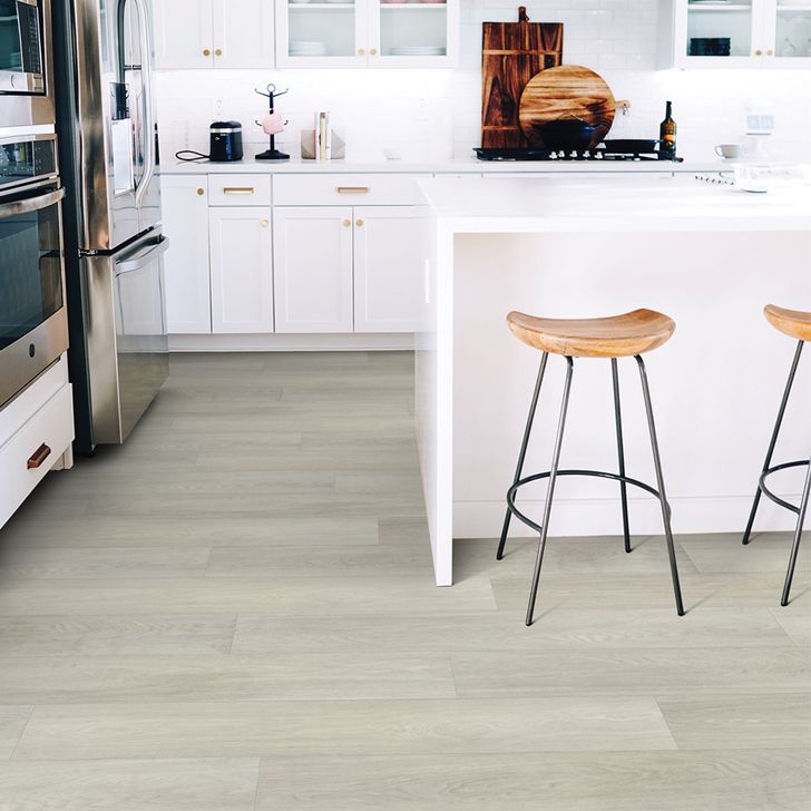 Modern kitchen with white cabinets, stainless steel appliances, and wooden stools.