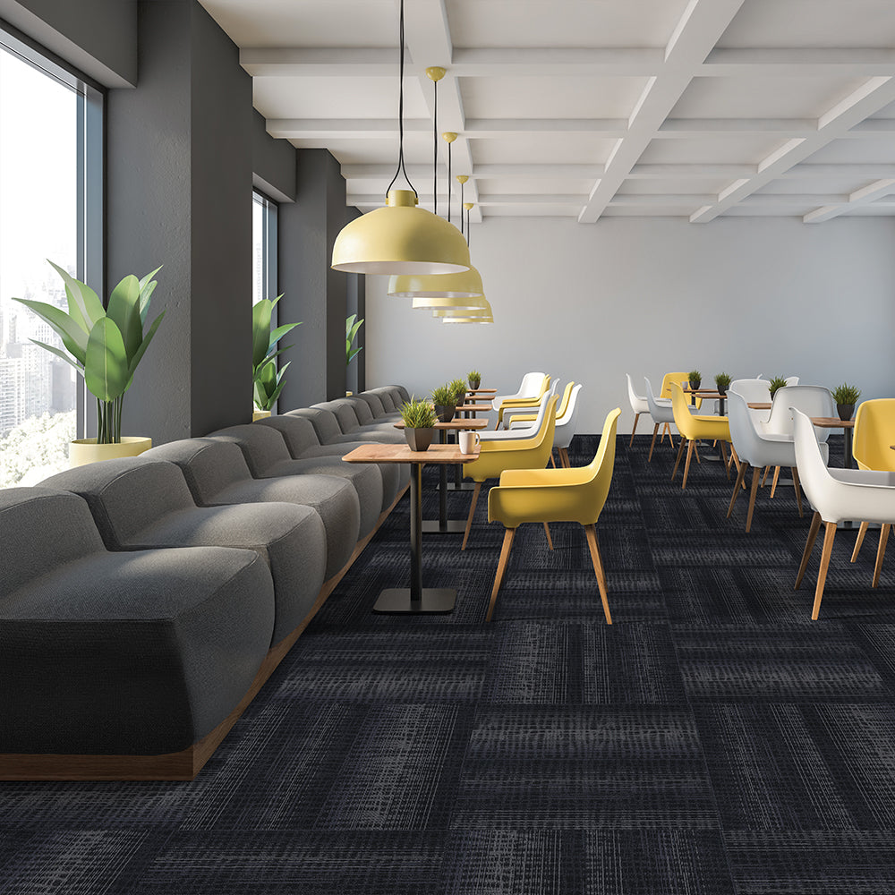 Modern office waiting area with gray couch, yellow chairs, and a large window.