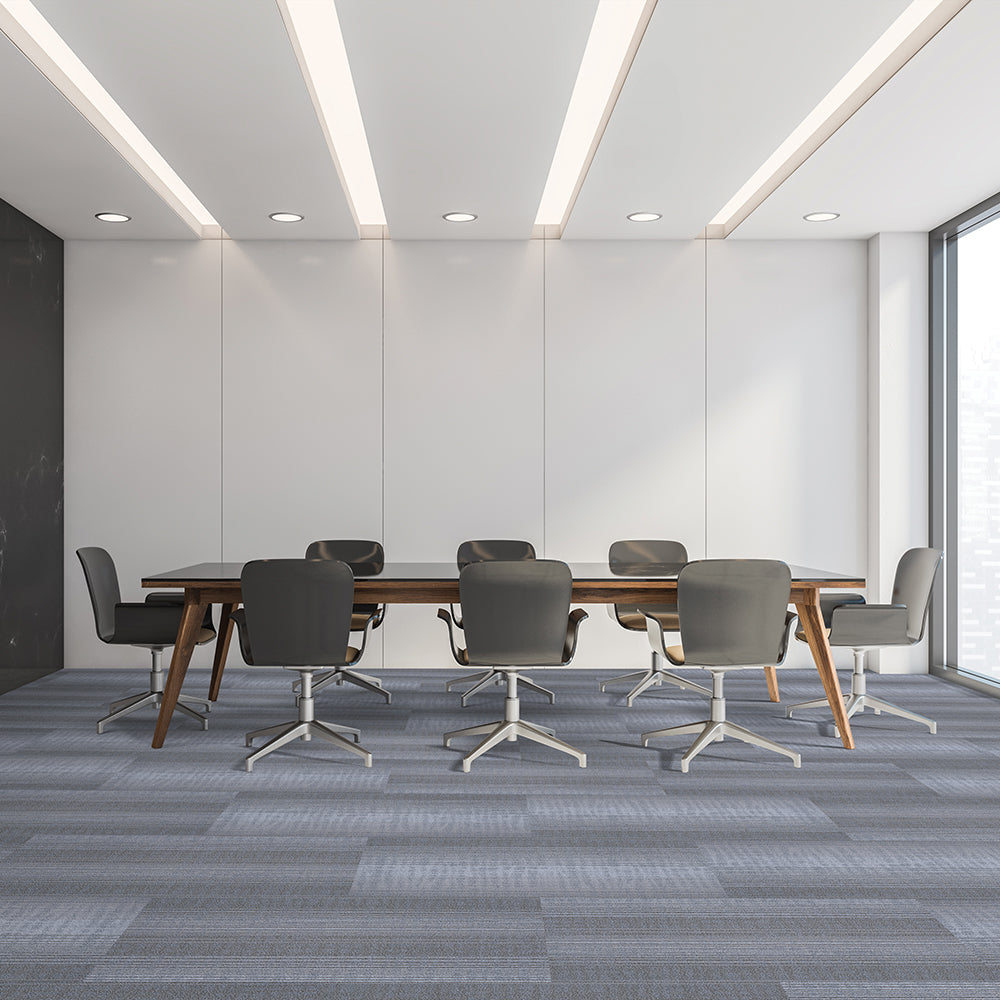 Modern conference room with a long wooden table and gray chairs.