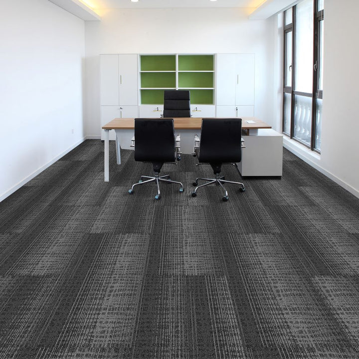 Modern office with gray carpet, black chairs, and a desk.