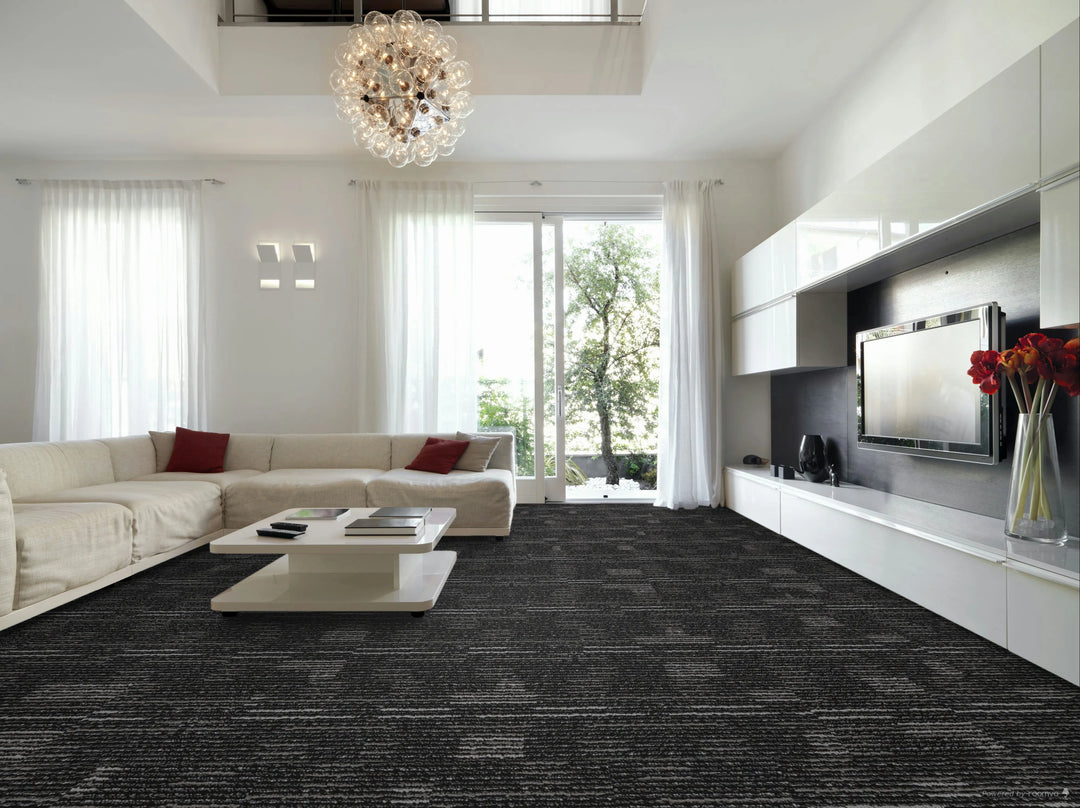 Modern living room with a gray carpet, white walls, and a large window.