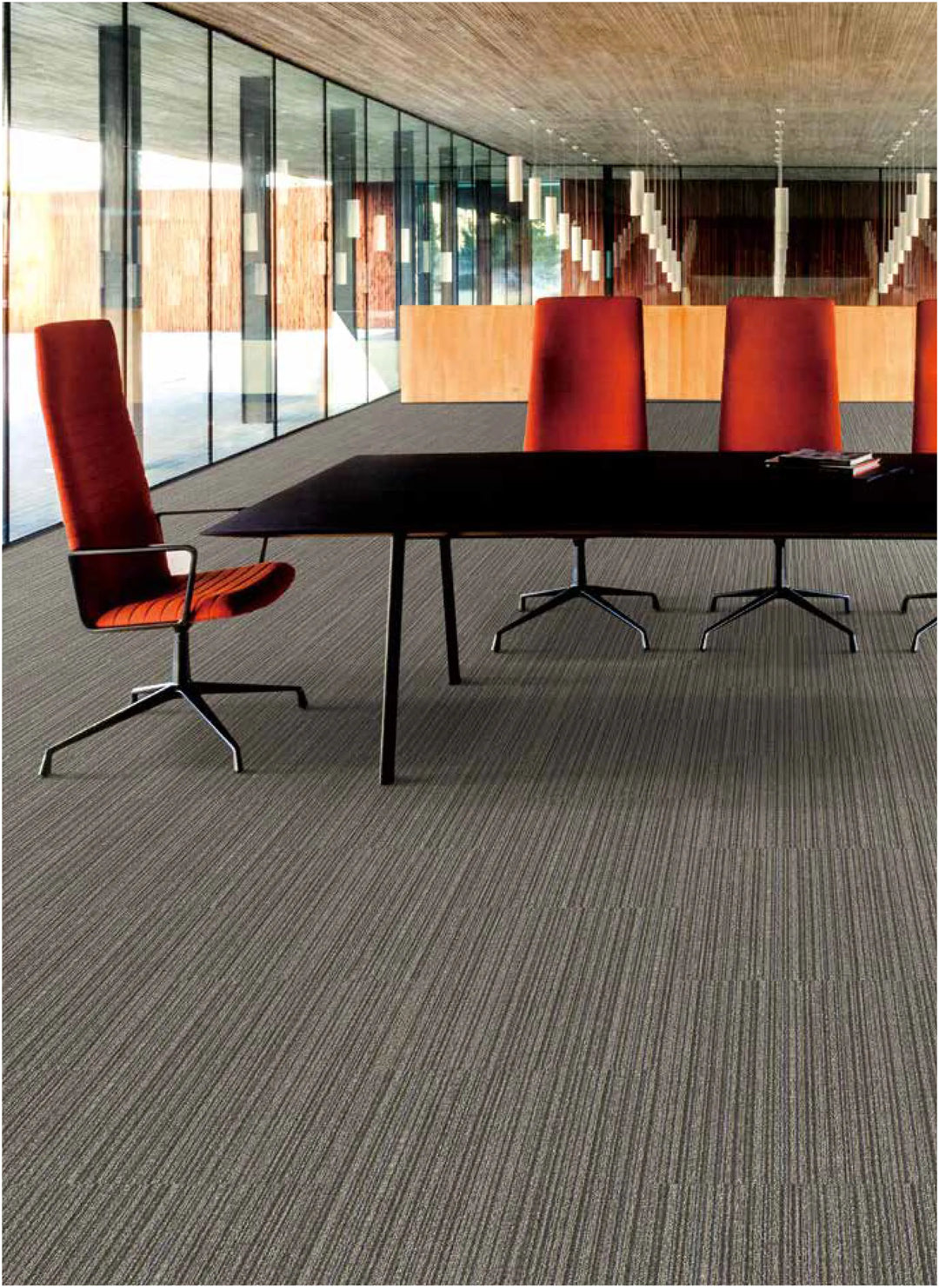 Modern office conference room with red chairs and a long table.