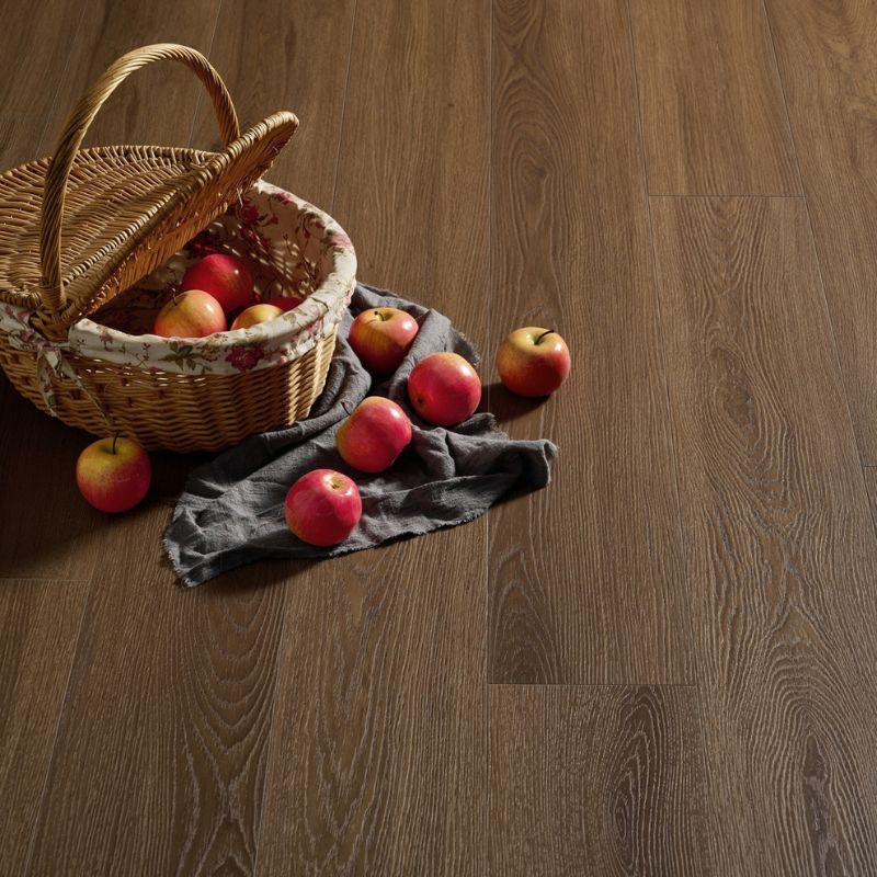 Close-up of Grandeur Inov8 SPC vinyl flooring in Peninsula shade, showing dark brown wood grain detail and natural texture with decorative props.