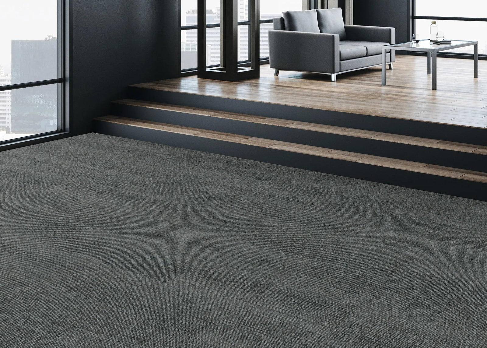 Modern office interior with gray carpeted floor and stairs leading to a seating area.