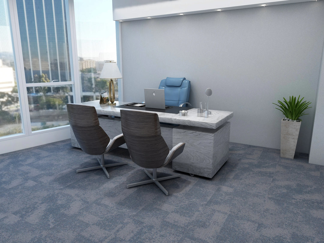 Modern office desk with chairs and a laptop in a bright room with large windows.