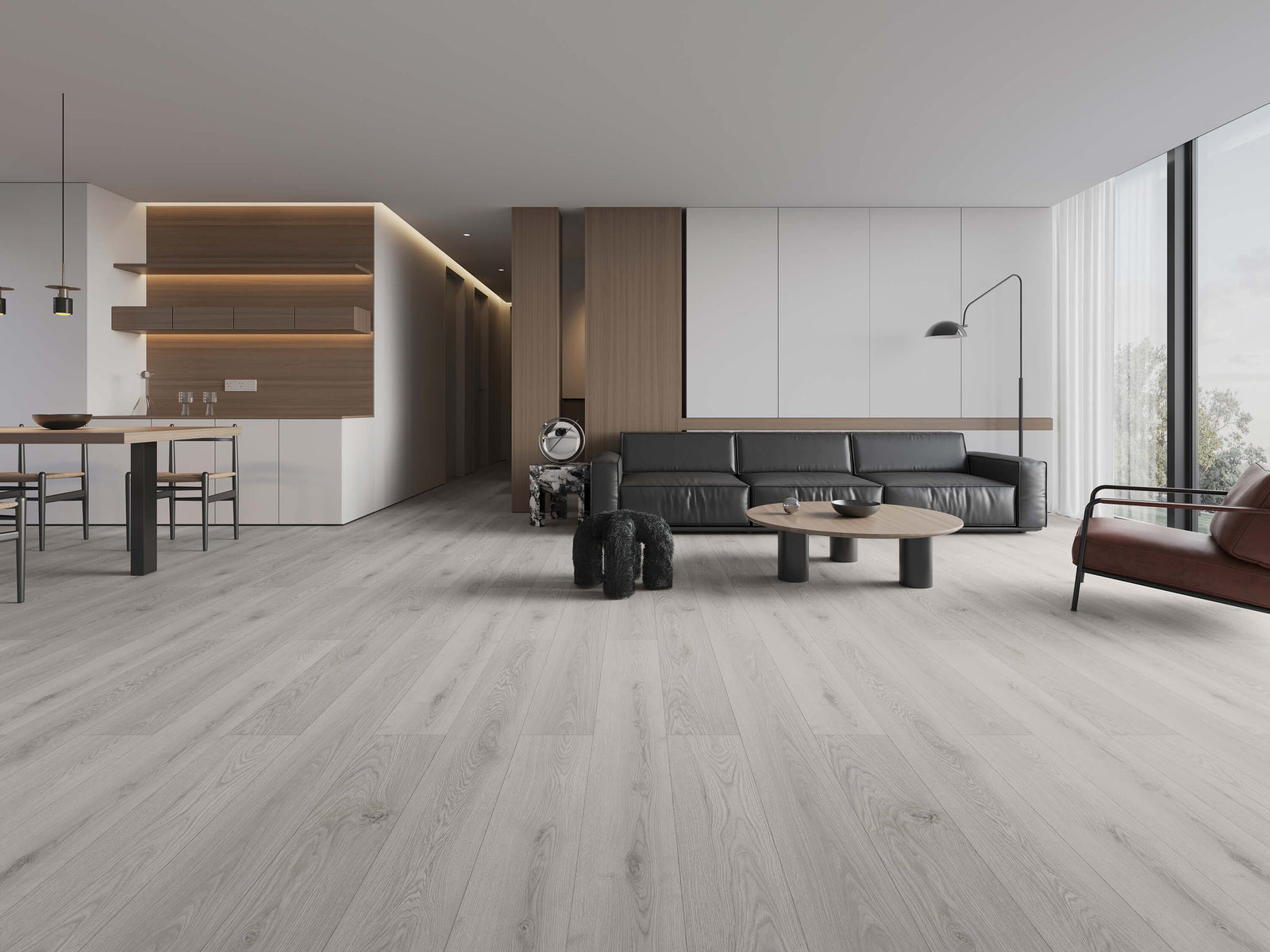 Light gray wood-look laminate flooring shown in a modern, minimalist living room with a black leather sofa. Available at Advanced Flooring Waterloo.
