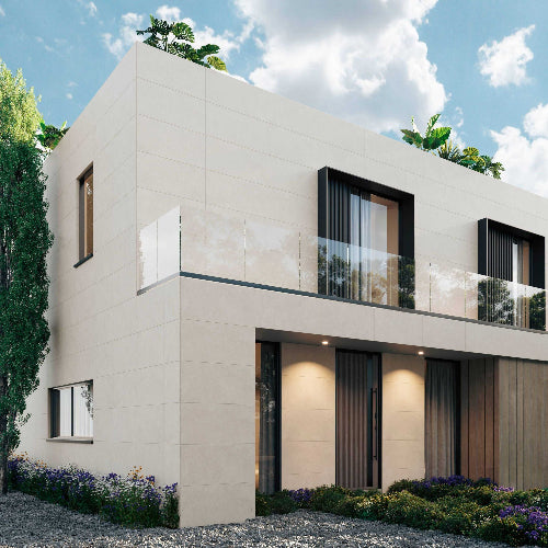 Modern house with beige exterior and glass windows under a blue sky.