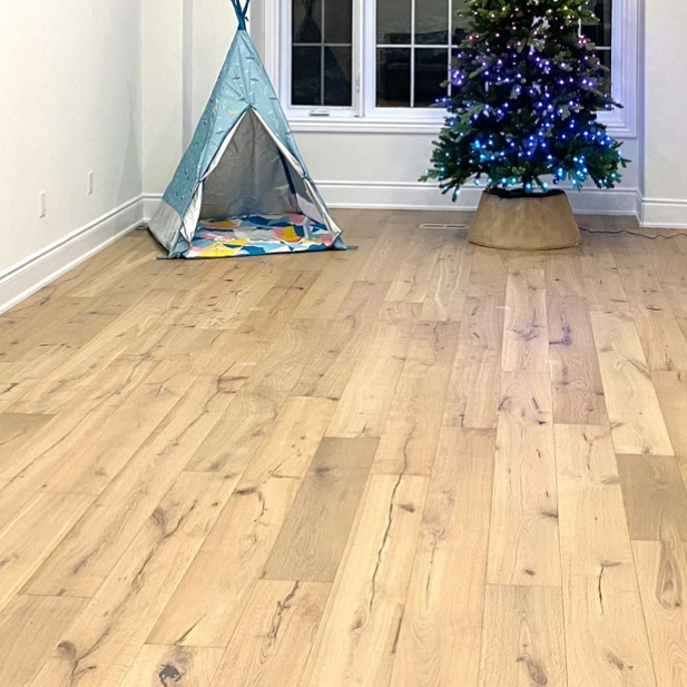 Wooden floor with a child's play area including a teepee and Christmas tree.