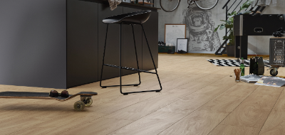 Modern kitchen with wooden floor, black bar stools, and various decor items.