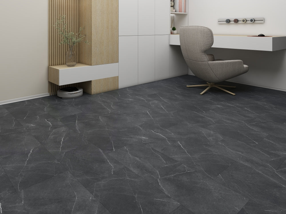 Modern room with dark stone tiles on the floor, a gray chair, and a white wall.