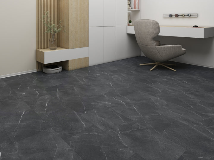 Modern room with dark stone tiles on the floor, a gray chair, and a white wall.