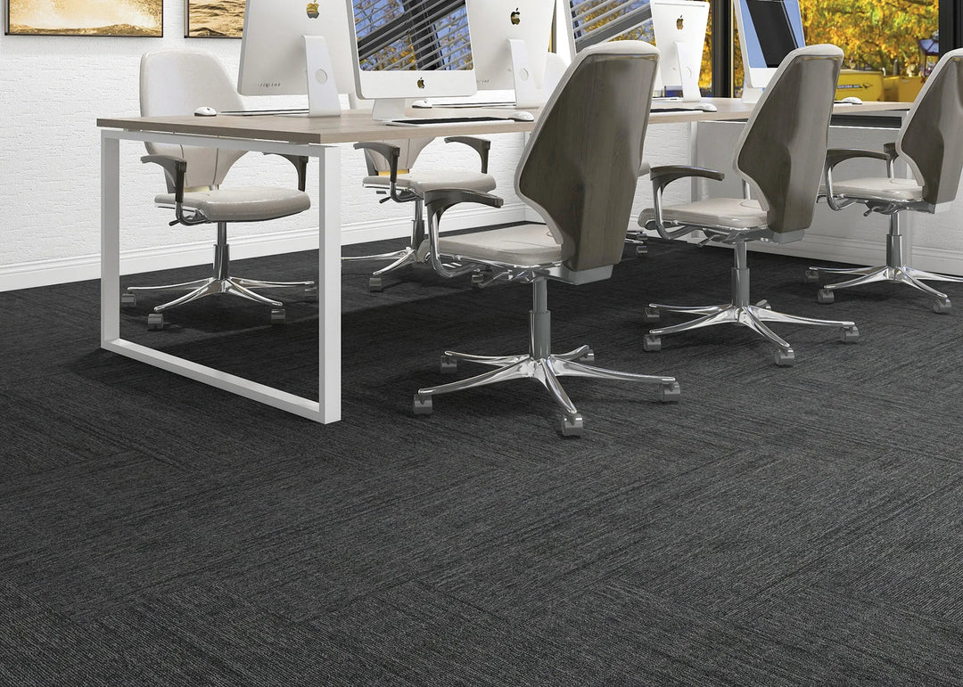 Modern office setup with a conference table and chairs on a textured gray carpet.
