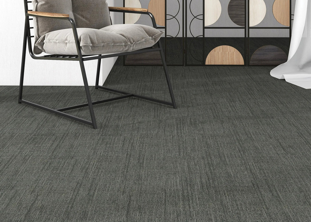 Gray carpeted floor with a chair and decorative elements in the background