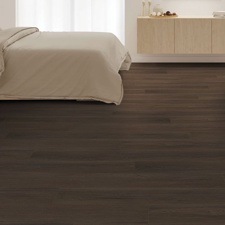 Bedroom with a wooden floor and neutral bedding.