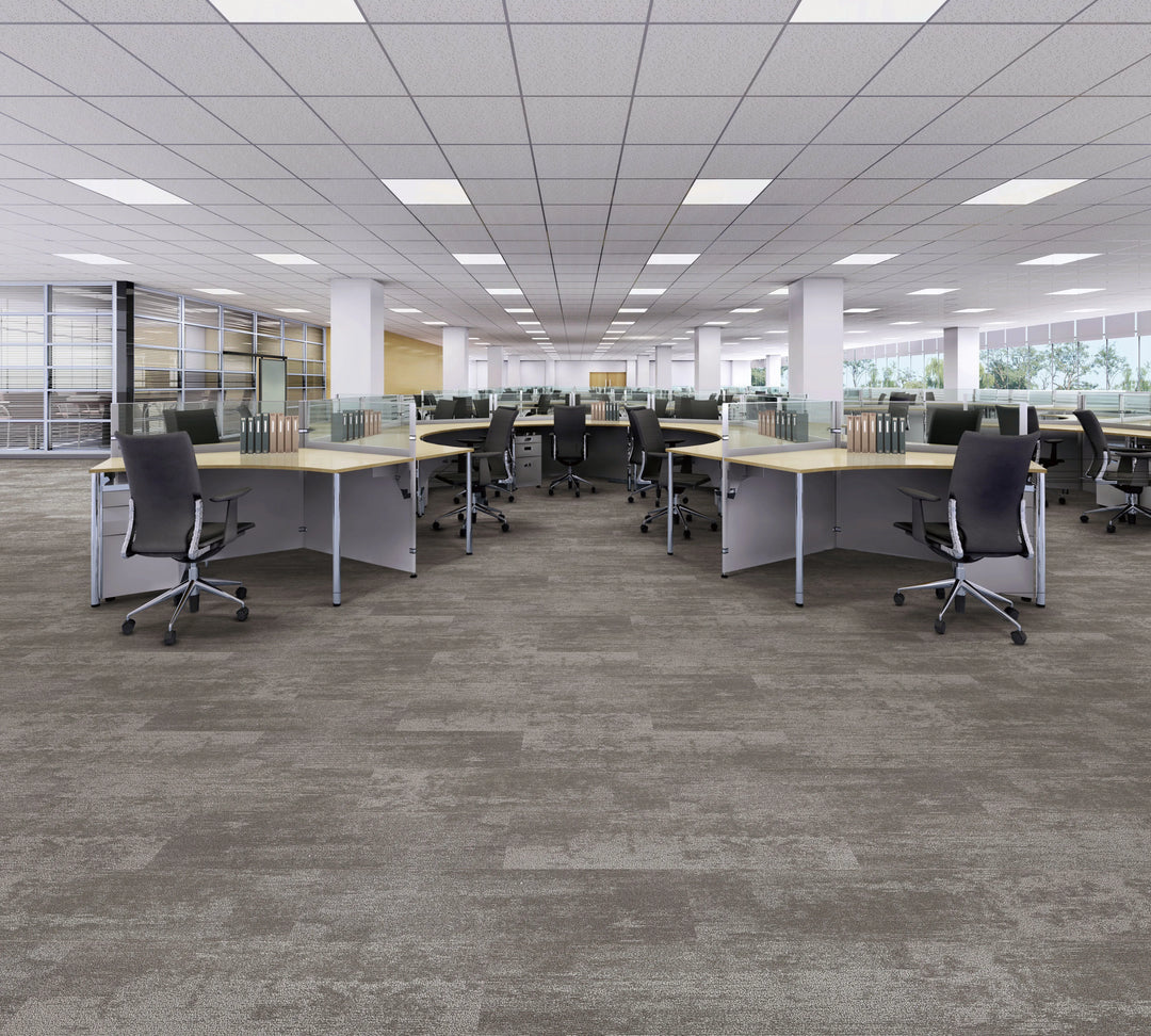 Modern office space with desks, chairs, and large windows.